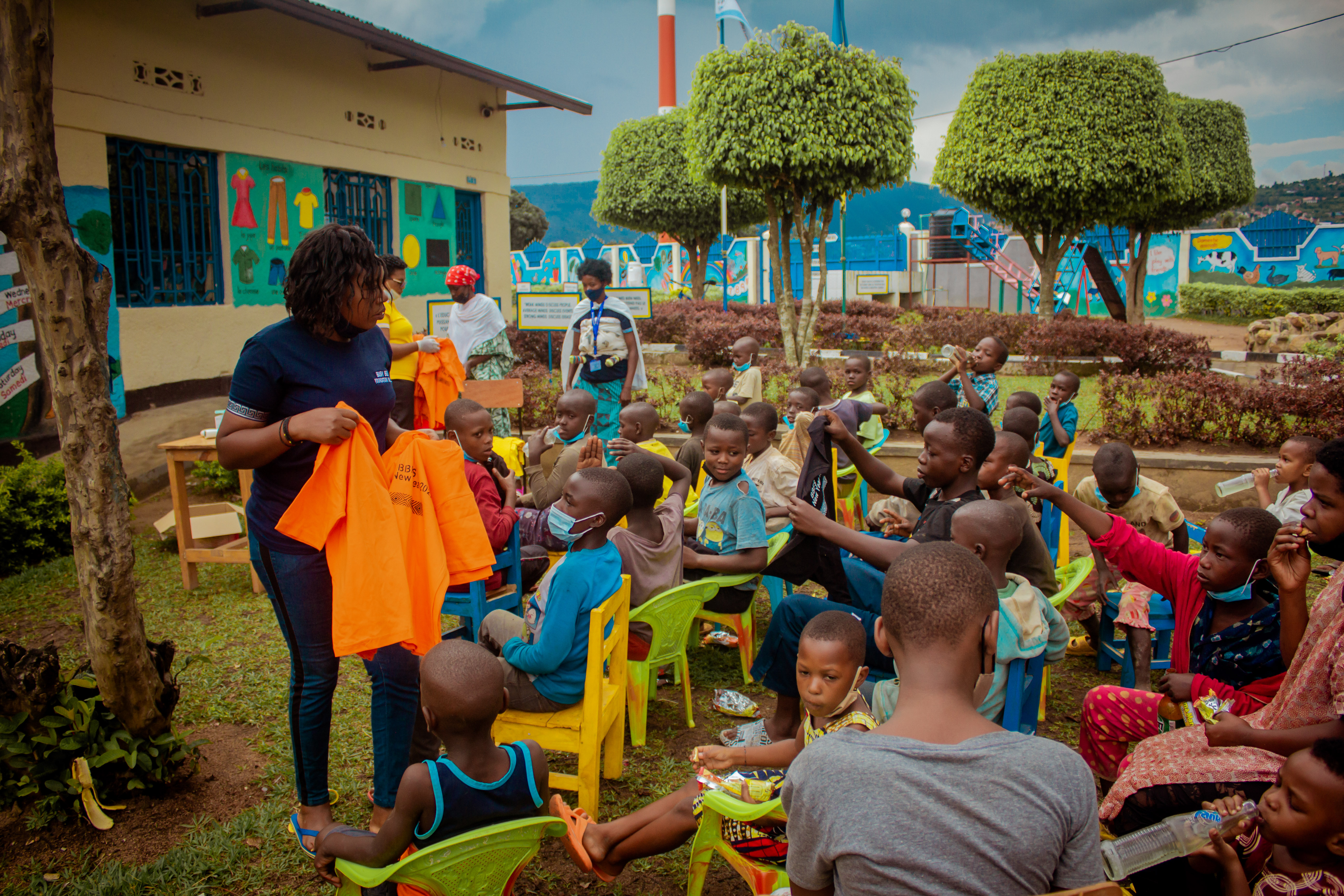 A Busy Bees Foundation volunteer handing out T-shirts to children at the Christmas gathering