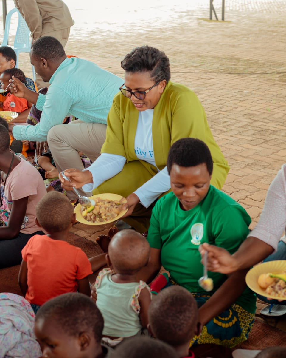 A Busy Bees Foundation volunteer feeding a child during a Women's Day nutrition event